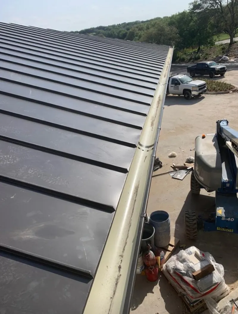 Standing seam panel and gutter detail on a metal roofing jobsite in Meadow Lakes